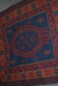 A Persian Islamic floor rug having a deep red and
