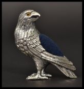 A sterling silver pin cushion in the form of an eagle with with glass eyes. In the manner of Adie