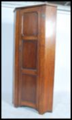 A 1930s 20th century oak bachelors corner wardrobe, having a full length panel door opening to