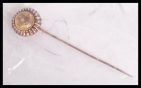 An Art Deco yellow metal pin set with a yellow stone in a sun burst mount. Measures 6.5cms. Weight