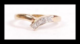 A hallmarked 9ct gold and diamond wishbone ring having illusion set accent diamonds. Hallmarked