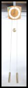 A retro 20th century Danish inspired brass weight and chain driven wall clock the body of the