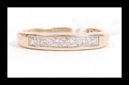 A hallmarked 9ct gold and CZ band ring being set with a square cut channel mounted CZ. Hallmarked