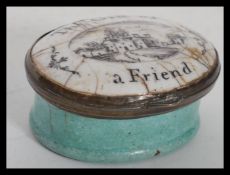 A 19th century Bilston enamel pill box pot having a pictorial lid of a house with notation reading