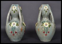 A pair of early 20th century Art Nouveau ceramic four handled vases having painted floral sprays and