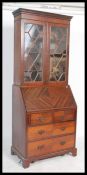 An Edwardian mahogany Liberty & Co of London bureau bookcase. The twin door bookcase cabinet with