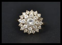 A hallmarked 9ct gold CZ cluster ring having a central white stone with a two layer cluster of