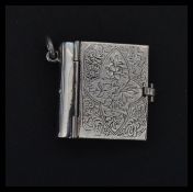 A sterling silver pendant in the form of a novelty miniature book. Weighs 15 grams.