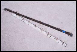 A pair of french vintage industrial steel butchers hooks all mounted on a steel strip with fastening