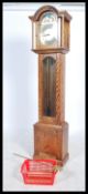 A 20th century oak cased Tempus Fugit longcase clock. The silvered dial with brass spandrels and