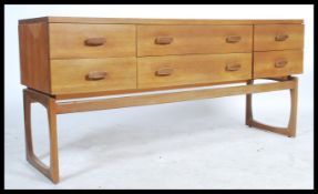 A 1970's retro G-Plan Quadrille pattern teak wood sideboard chest raised on squared legs with a