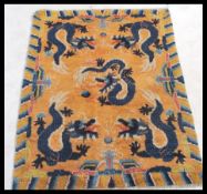 An early 20th century Tibetan dragon rug.  The orange ground with 5 dragons chasing flaming pearls