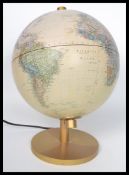 A retro 20th century illuminated terrestrial desk top globe raised on a gilt pedestal base, the