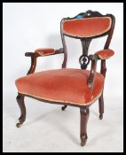 A 19th century Victorian inlaid and carved elbow mahogany salon arm chair raised on turned legs on