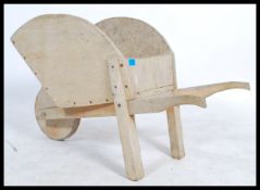 A 19th century Victorian Child's wheelbarrow of elm construction having a central wheel to the