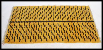 An early 20th century Tibetan tiger rug. Yellow ground with black tiger striping, tassled ends.