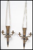 A pair of 20th century gilt and ebonised brass wall sconces of scrolled form having armorial eagle