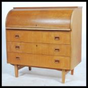 A 1960's retro teak wood roll top  cylinder bureau having three drawers with inset handles raised on