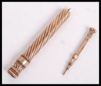 A hallmarked 9ct gold propelling pencil having a twist design along with a miniature pencil unmarked