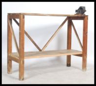 A vintage scratch built 20th century work bench, constructed from reclaimed pine planks, the top