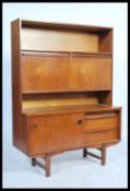 A retro 1960's teak wood highboard unit comprising of twin floating drop down cupboards raised above