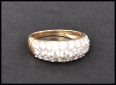 A hallmarked 9ct gold and CZ ring having ribbed shoulders and pave set CZ. Hallmarked Sheffield.