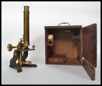 A late 19th century lacquered and painted brass monocular microscope, with eyepieces and slides,