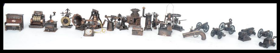 A collection of approximately 24 20th century Spanish Play Me novelty pencil sharpeners in a bronzed