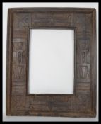 A vintage 20th century hard wood carved African picture frame, the frame heavily carved with African