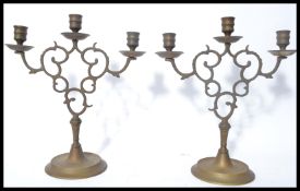 A 19th century Victorian cast brass pair of candelabra candlesticks's raised on stepped circular