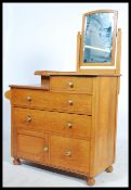 A 1930's Waring & Gillows solid oak dressing table / chest of drawers having an arrangement of