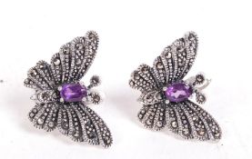A pair of sterling silver and marcasite earrings in the form butterflies having amethyst stones.