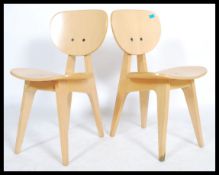 A pair of 20th century retro vintage steamed ply chairs raised on angular legs. Measures 79cm x 42cm
