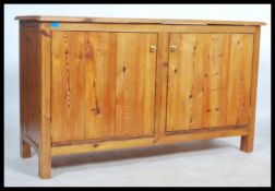 A contemporary 20th century pine dresser base cupboard. Of plain panel form with double doors having