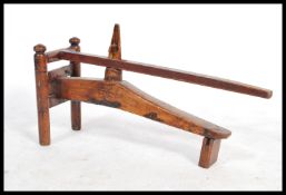 A late 19th century antique oriental fruit press having a pivoting lever and wedge to crush the