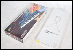 A contemporary electric keyboard / piano / organ with stand by Power Play retaining original boxes.