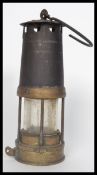 An early 20th century cast metal and brass miners lamp having a hook atop. Measures 26 cm high