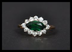 A hallmarked 9ct gold ring set with green and white stones. Hallmark worn - tests 9ct gold. Weight 2