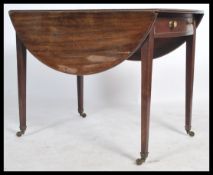 A 19th century Georgian mahogany pembroke table being raised on squared tapering legs with