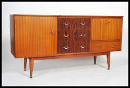 A retro 1970's teak wood sideboard dresser being raised on tapering legs with drawers and
