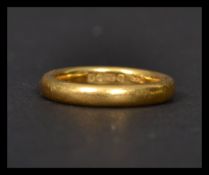 A ladies small hallmarked 22 ct gold band ring of usual form, With a Birmingham hallmark, date