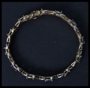 A 925 gilded silver sapphire adorned ladies tennis bracelet. The bracelet with 12 sapphires having