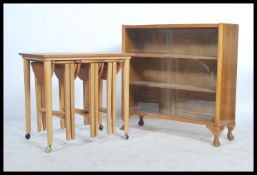 A retro teak wood quartetto nest of tables raised on turned legs with a series of tables to