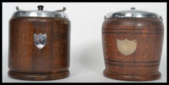 Two vintage 20th century oak biscuit barrels having silver white metal mounts and lids. One barrel