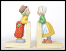 A pair of vintage mid 20th century ceramic bookend of a boy and girl in the manner of Hummel stamped