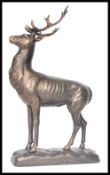 A vintage cast iron figurine of a deer stag with antlers raised on a naturalistic base. Measures