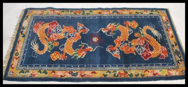 An early 20th century Tibetan double dragon rug. The blue ground with 2 dragons surrounded by