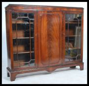 An early 20th century mahogany display cabinet bookcase, central panel cupboard door flanked by