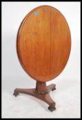 A Victorian mahogany tilt top loo table having a faceted octagonal tapering column supported by a