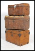 A group of three vintage 20th century industrial luggage tin trunks having folding handles to